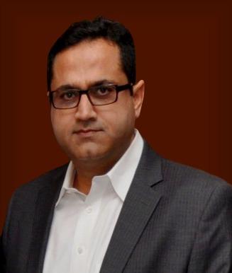 ejaz_adams_professional_headshot_wearing_grey_suit_and_white_shirt.jpeg